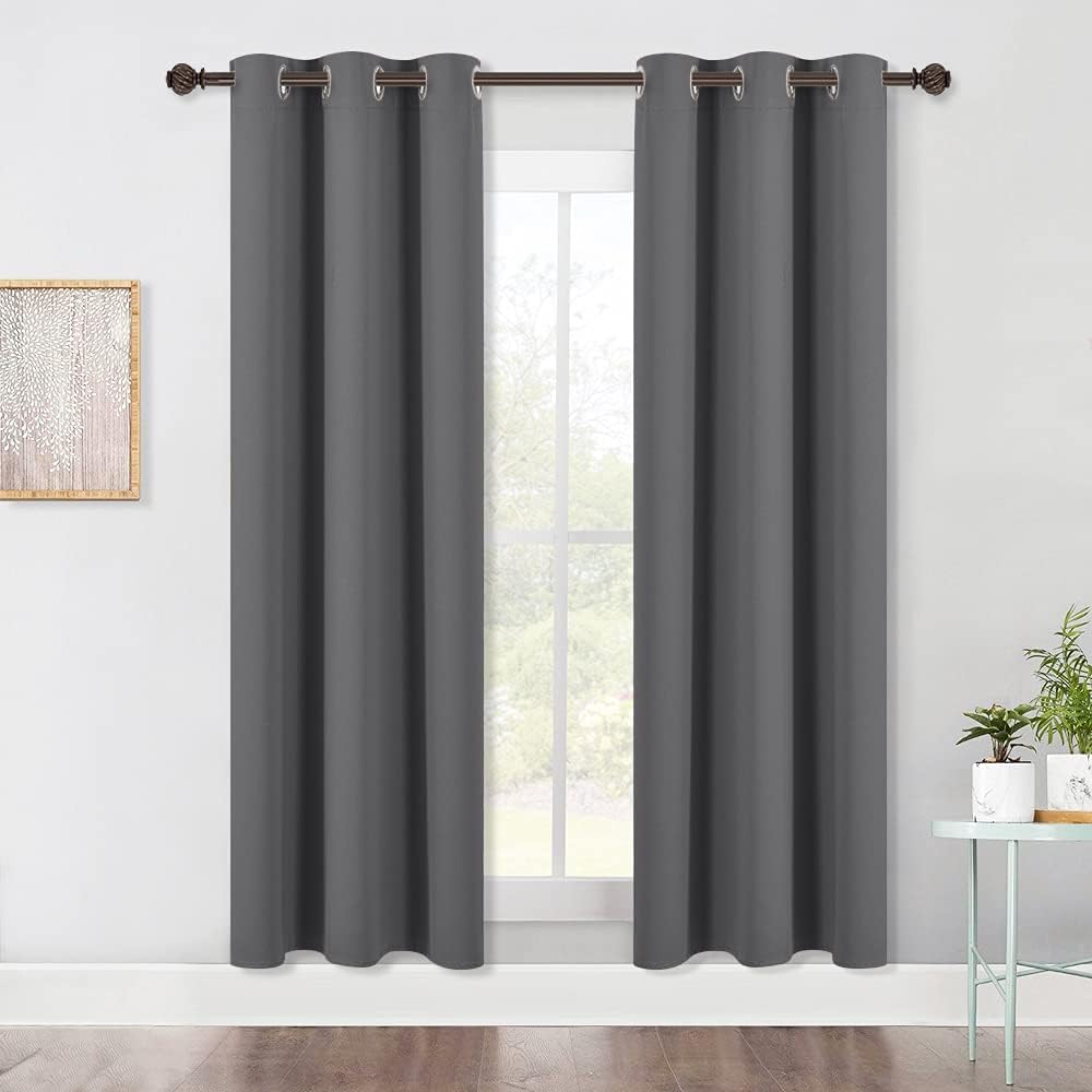 Pair of grey 42 x 72 in blackout grommet curtains hanging at a window