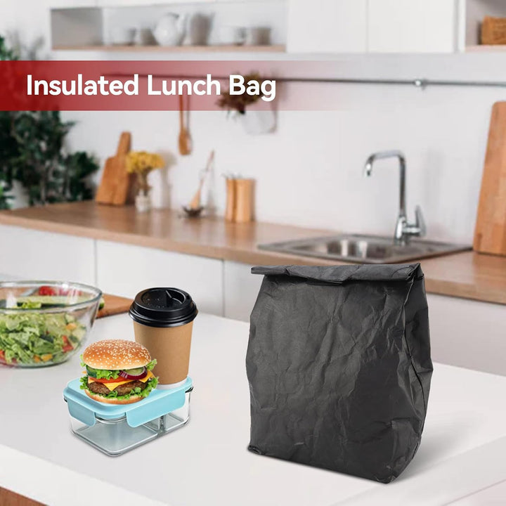 Black insulated lunch bag standing beside lunch items