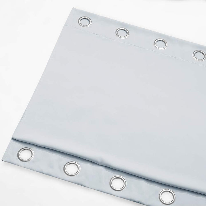Greyish white outdoor curtain folded with top and bottom grommets