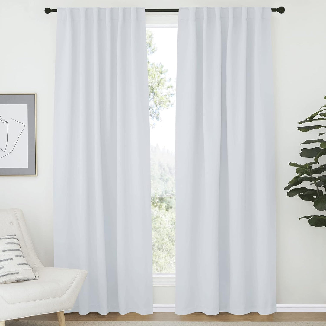 Greyish white two-panel curtains hanging by back tabs
