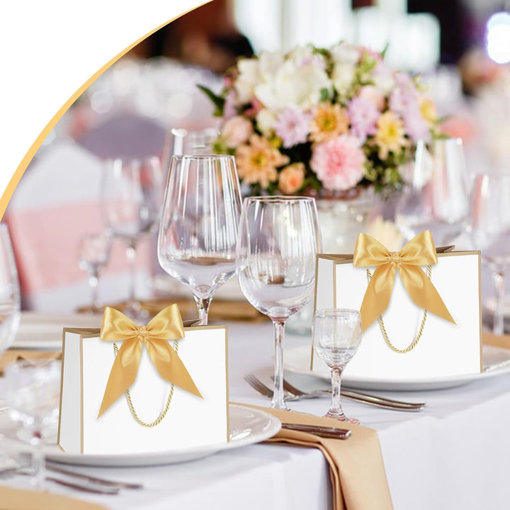 White and pink mini paper gift bags with gold handles and bows
