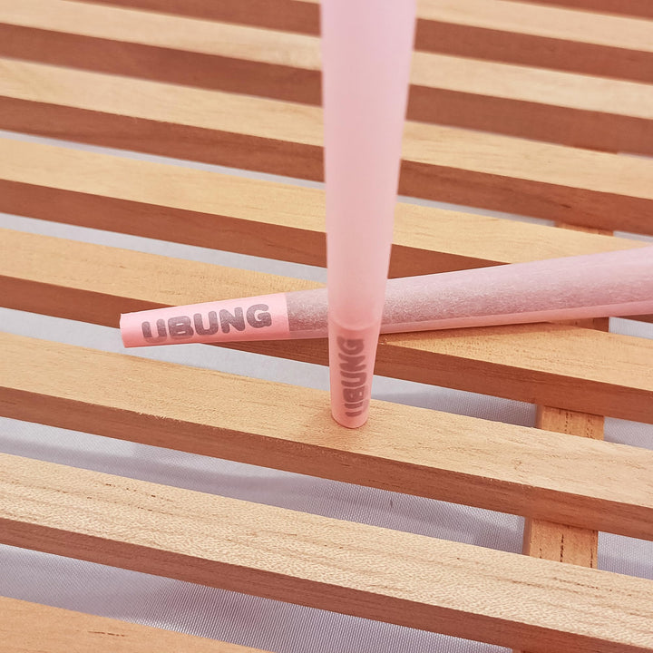 Close view of two light pink pre-rolled cones