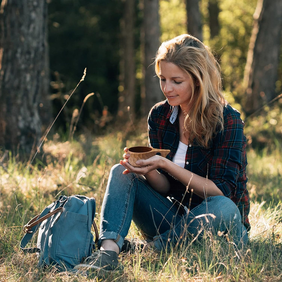 Wooden camping cup held outdoors